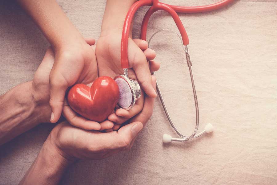 A healthcare professional holds a heart with a stethoscope, illustrating the commitment of Bonneville Family Practice to wellness.