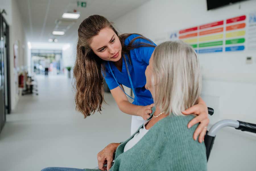 A nurse assists an elderly woman in a wheelchair at Bonneville Family Practice, showcasing compassionate care and support.