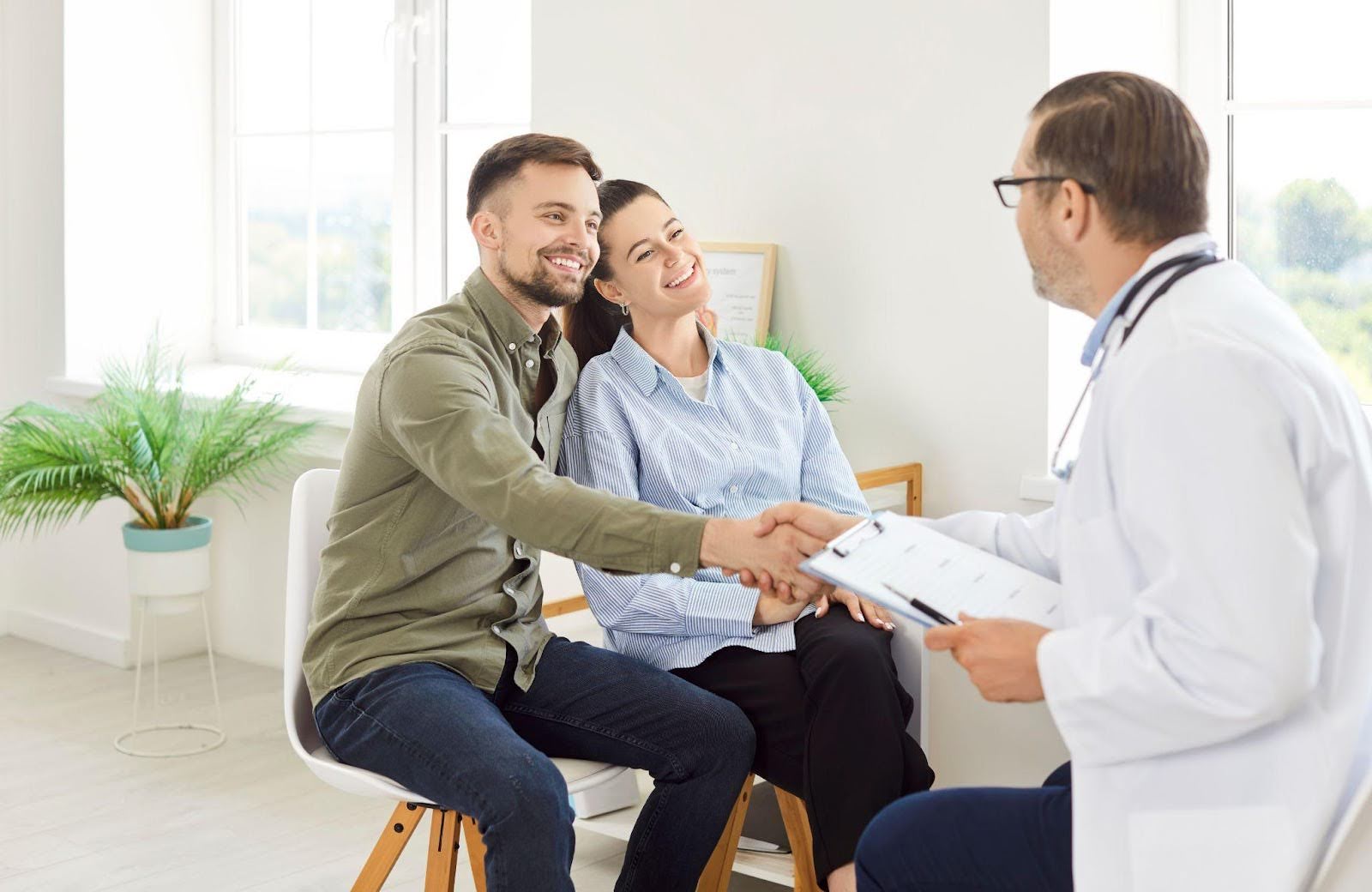 A man and woman sit together in a doctor office waiting for their appointment
