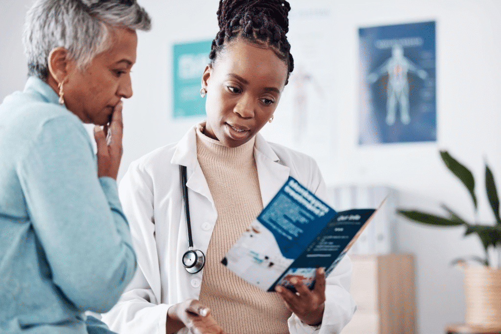 A woman discusses health options with a doctor while examining a brochure in a medical office