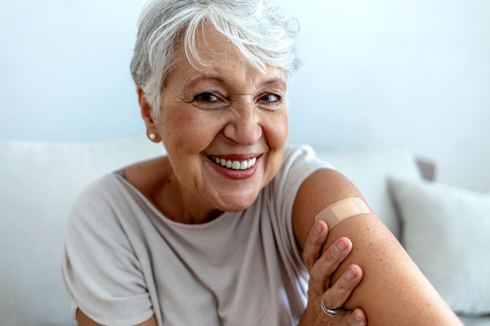 An older woman with a bandage on her arm, representing insurance-covered medical services.