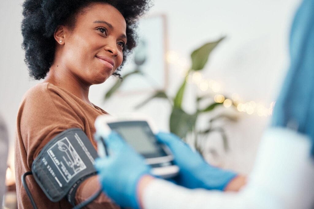 A woman is using a blood pressure monitor emphasizing the importance of regular health monitoring